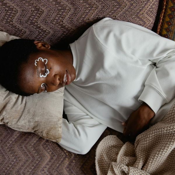Woman peacefully closing her eyes in a calm, dark environment with light accents.